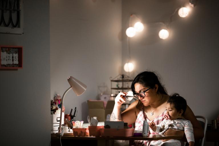 Mother Working From Home at Desk While Holding Baby Daughter 1262580236 2125x1416